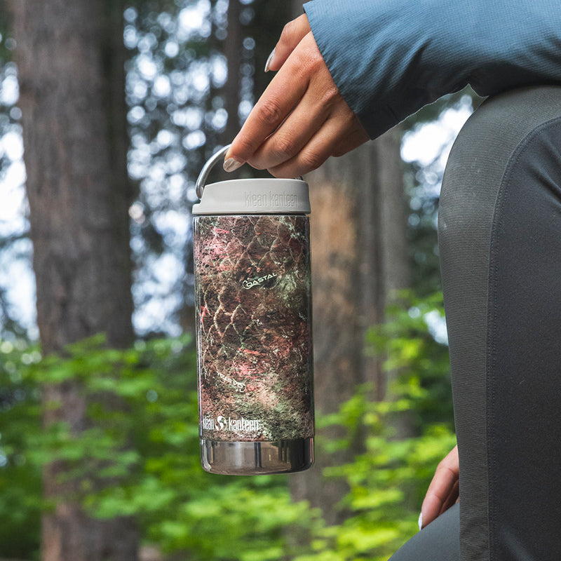 12oz-tkwide-with-cafe-cap-mossy-oak-n8 12oz_tumbler_mossyoak_rainbowtrout_hand_closeup_square.jpg